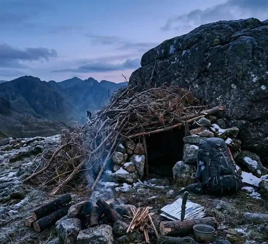 Refugio de emergencia construido con elementos naturales en la montaña.